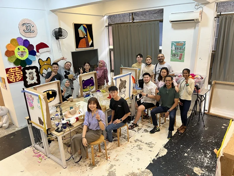 A full studio of people tufting